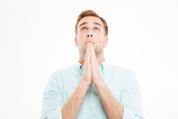 Closeup of peaceful young businessman praying and looking up - Photo, Image