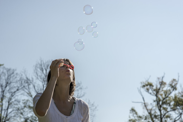Frau pustet Blasen nach draußen - Foto, Bild