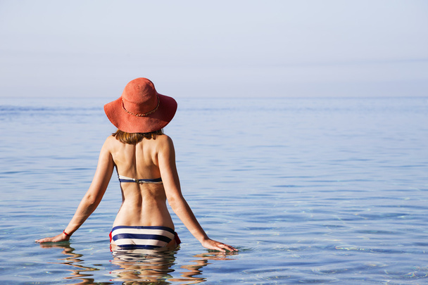 Young beautiful woman sunbathing on the sea - Photo, Image