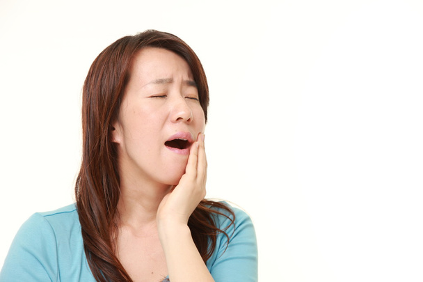 middle aged Japanese woman suffers from toothache - Foto, afbeelding