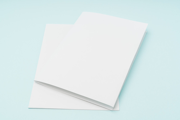 Bifold white template paper on blue background . - Foto, Imagem