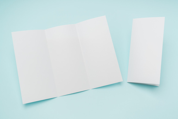 Trifold white template paper on blue background . - Foto, Imagem