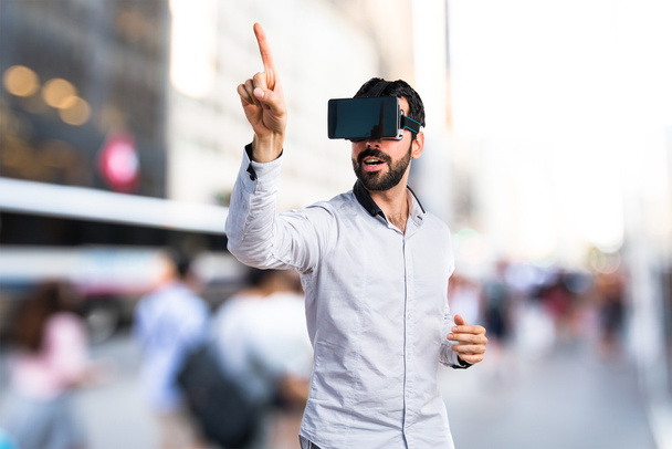 Hombre usando gafas VR tocando en pantalla transparente
 - Foto, Imagen