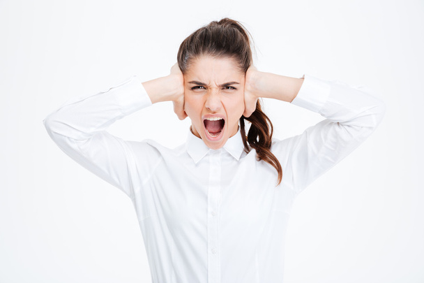 Businesswoman covering her ears and shouting over white background - Foto, Imagem