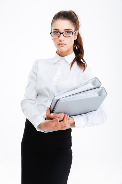 Beautiful young businesswoman standing and holding folders with documents - Zdjęcie, obraz