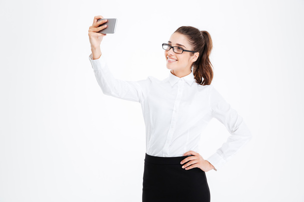 Smiling business woman in glasses making selfie using cell phone - Valokuva, kuva