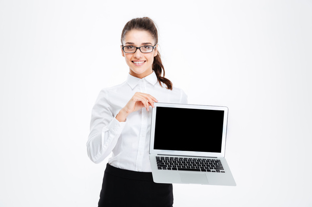 Cheerful attractive young businesswoman in glasses holding blank screen laptop - Φωτογραφία, εικόνα