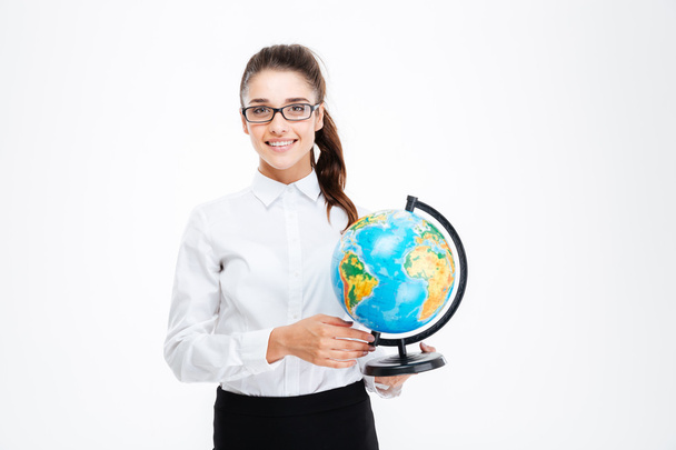 Smiling beautiful young busineswoman in glasses standing and holding globe - Fotografie, Obrázek
