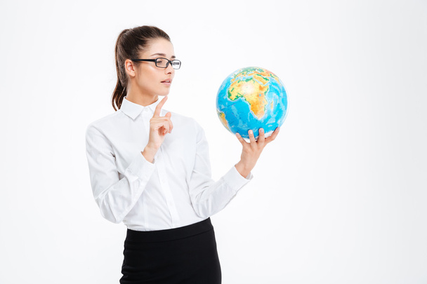 Thoughtful beautiful young businesswoman holding globe and thinking - Фото, изображение