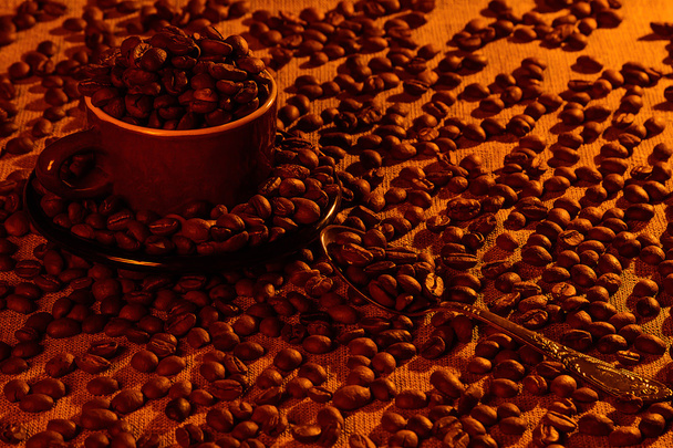 カップとスプーン、荒布を着たコーヒー豆の完全  - 写真・画像