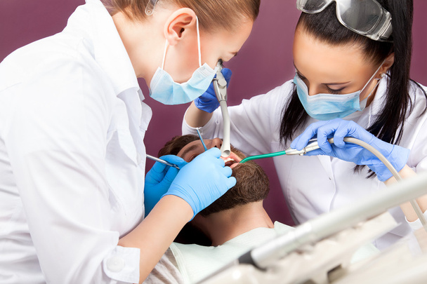 Vrouw tandarts arts maakt tanden check-up voor patiënt mannen - Foto, afbeelding