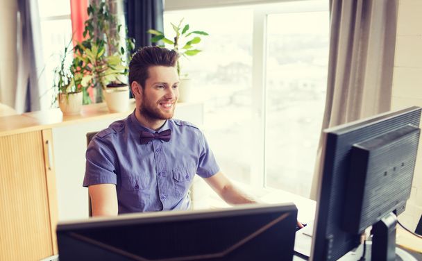 happy creative male office worker with computer - Фото, зображення