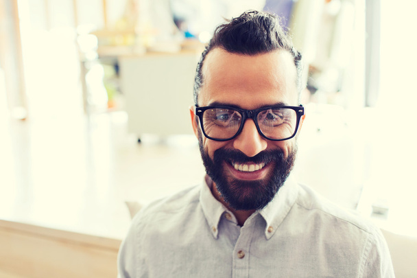 smiling man with eyeglasses and beard at office - Foto, afbeelding
