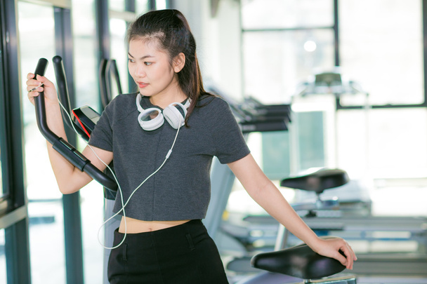 Σπορ κορίτσι με ακουστικά χαλαρώνοντας στο γυμναστήριο, άσκηση εργάζονται έξω - Φωτογραφία, εικόνα