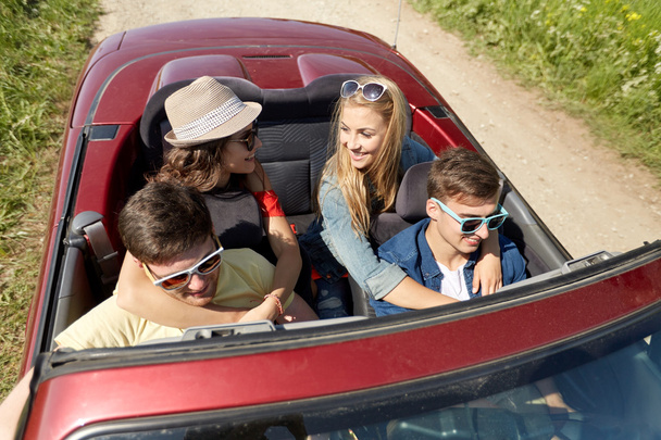 happy friends driving in cabriolet car at country - Photo, Image