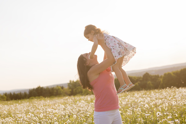 happy joyful mother with daughter daisy field - Foto, immagini