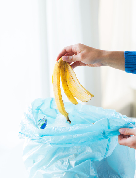 close up of hand putting food waste to rubbish bag - Foto, Bild