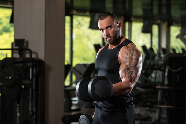Fitness Muscle Man Exercise Biceps With Dumbbells - Fotografie, Obrázek