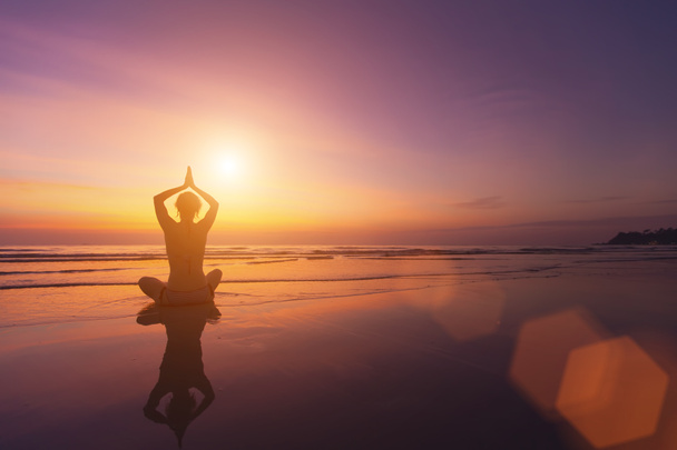 Silhouet van een meisje in een pose van yoga - Foto, afbeelding
