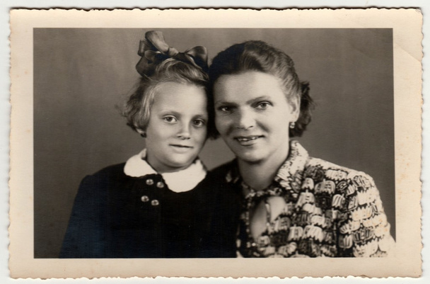 Ein historisches Foto zeigt Mutter und kleine Tochter. Retro Schwarz / Weiß Studiofotografie. - Foto, Bild