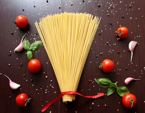 Інгредієнти для приготування макаронних виробів з помідорами, чорною макаронами, травами, спеціями
. - Фото, зображення