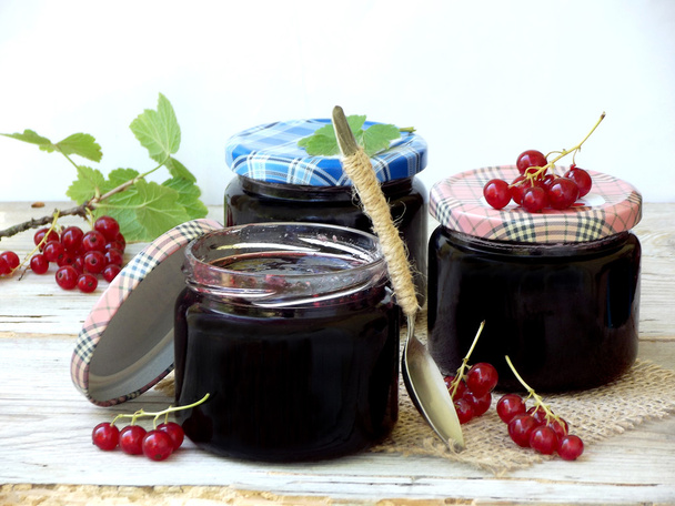 Three jar of jam from the red currant on a wooden background - Photo, Image