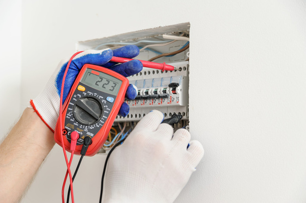 Electrician check voltage in electrical fuse box. - Foto, Bild