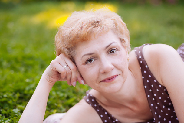 Portrét středního věku ženy usmívající se v parku - Fotografie, Obrázek
