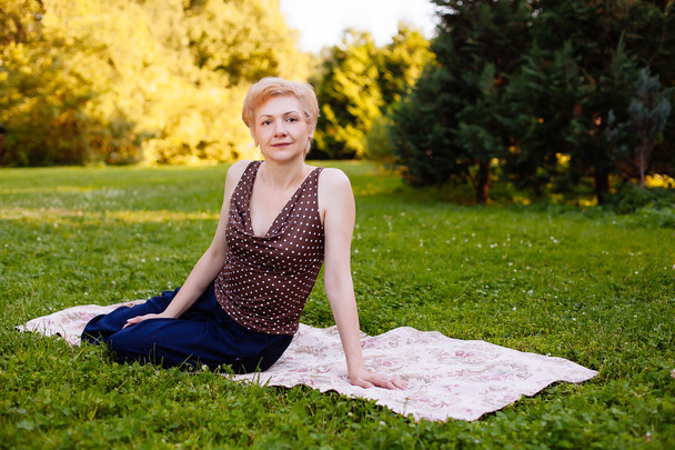 Portrait of middle aged woman smiling in the park - Photo, image