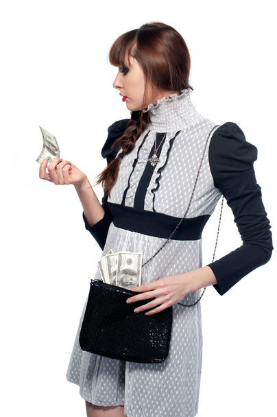 Uma jovem olha para o dinheiro. Em um fundo branco
. - Foto, Imagem