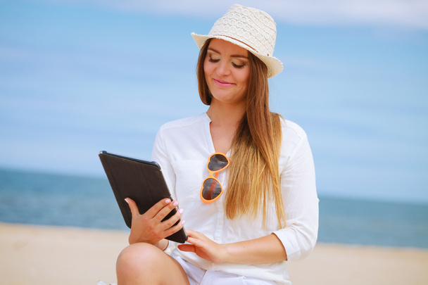 Girl with tablet on seaside. - 写真・画像