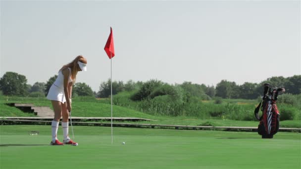 Woman prepares for the putting at the golf - Footage, Video