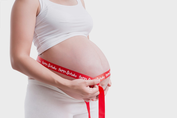 pregnant women 9 month measuring belly in a white background. - Photo, Image