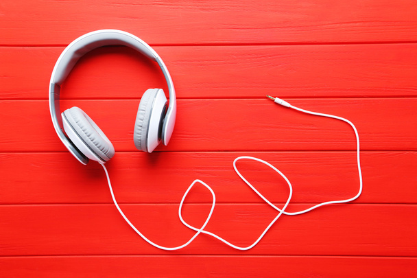 Headphones on a red wooden table - Foto, Imagen