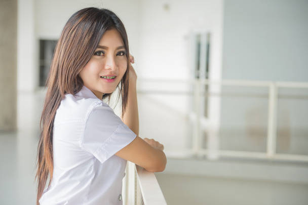 joven atractivo asiático chica en un uniforme de la universidad
 - Foto, Imagen