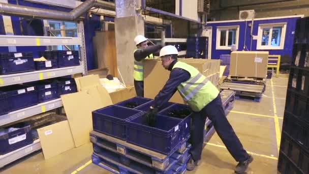 Workers unloading boxes with details - Footage, Video