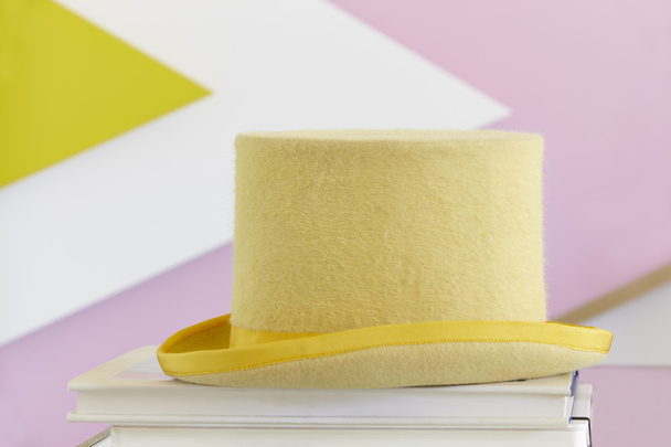 Sombrero amarillo bodegón con libros y pared pintada
 - Foto, Imagen