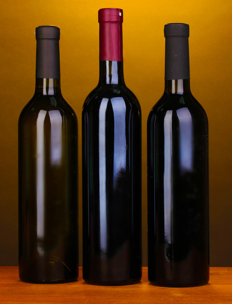 Bottles of great wine on wooden table on brown background - Foto, immagini