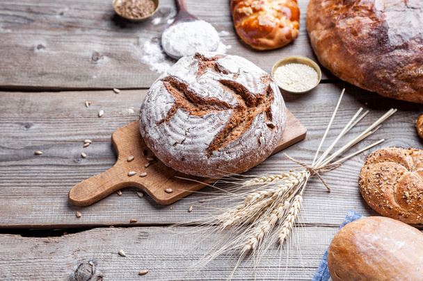 Delicious fresh bread on wooden background - Photo, image