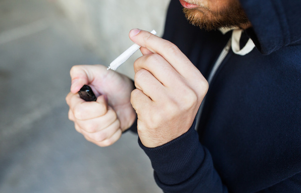 close up of addict smoking marijuana joint - Foto, Bild