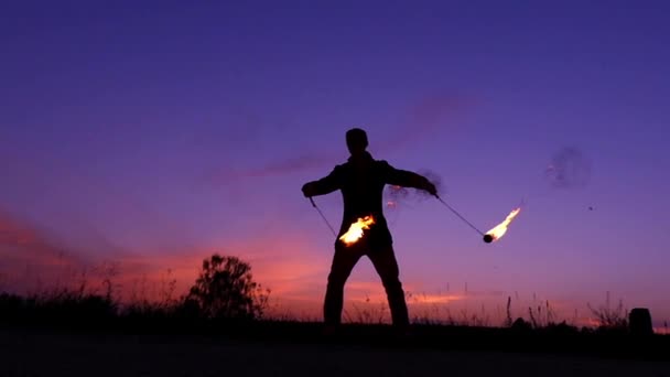 Niesamowity pokaz ognia o zachodzie słońca. Cyrk mężczyzna pracujący z ogniem Poi. Zwolnionym tempie. - Materiał filmowy, wideo