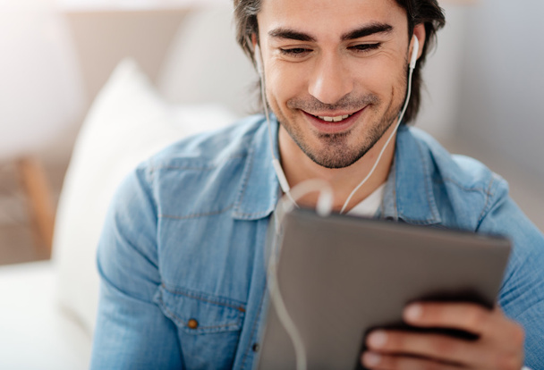 Positive smiling man using tablet - Photo, image