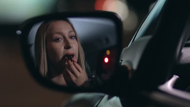 Jonge vrouw toepassing van rode lippenstift in de auto - Video