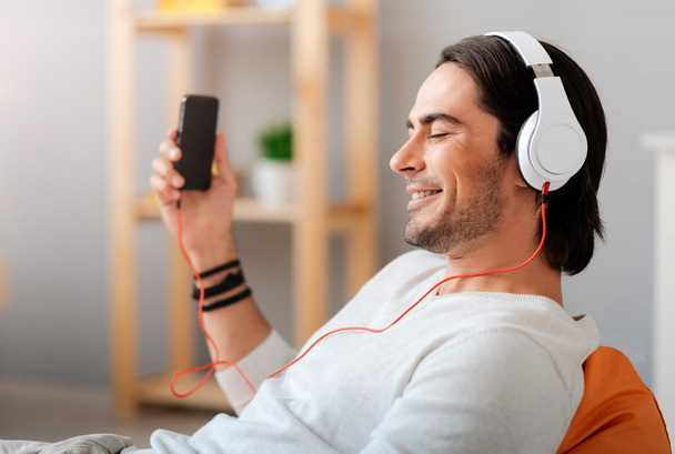 Positive man listening to music - Foto, afbeelding