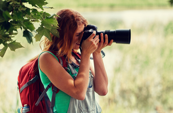 young woman with backpack and camera outdoors - Fotografie, Obrázek