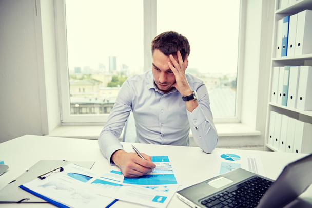 stressed businessman with papers in office - Foto, Bild