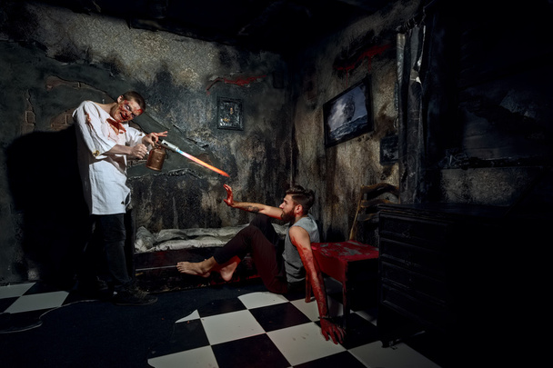 Psycho killer tortures with gas burner miserable victim - Valokuva, kuva
