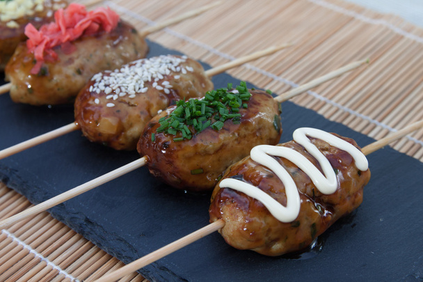 dania kuchni japońskiej, piłkę mięsa kurczaka Yakitori Tsukune podawane z topings, cebula i żółtko. - Zdjęcie, obraz