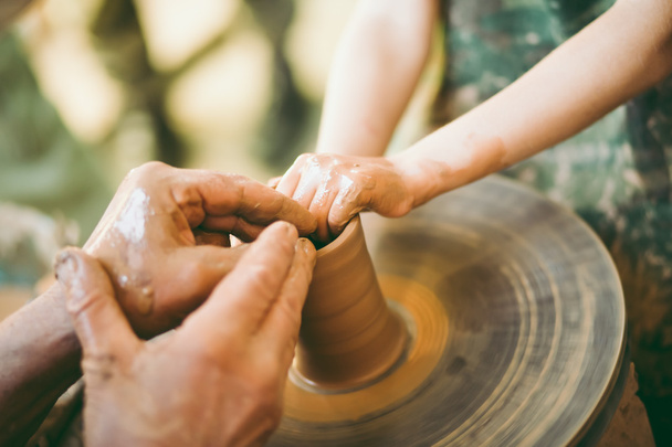 Potter teaches to sculpt a clay pot - Photo, Image