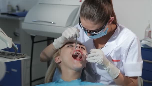 Dental surgeon applies dental probe to examine patients teeth - Footage, Video